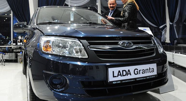 На фото: покупательница у автомобиля "Лада Гранта" в одном из автосалонов